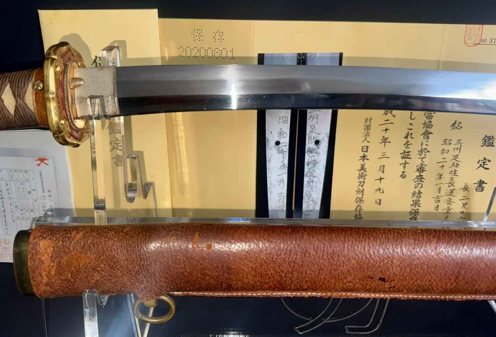 Chōunsai Shigemitsu katana, 1945 Japanese sword, blade and gold tsuba visible with brown leather saya