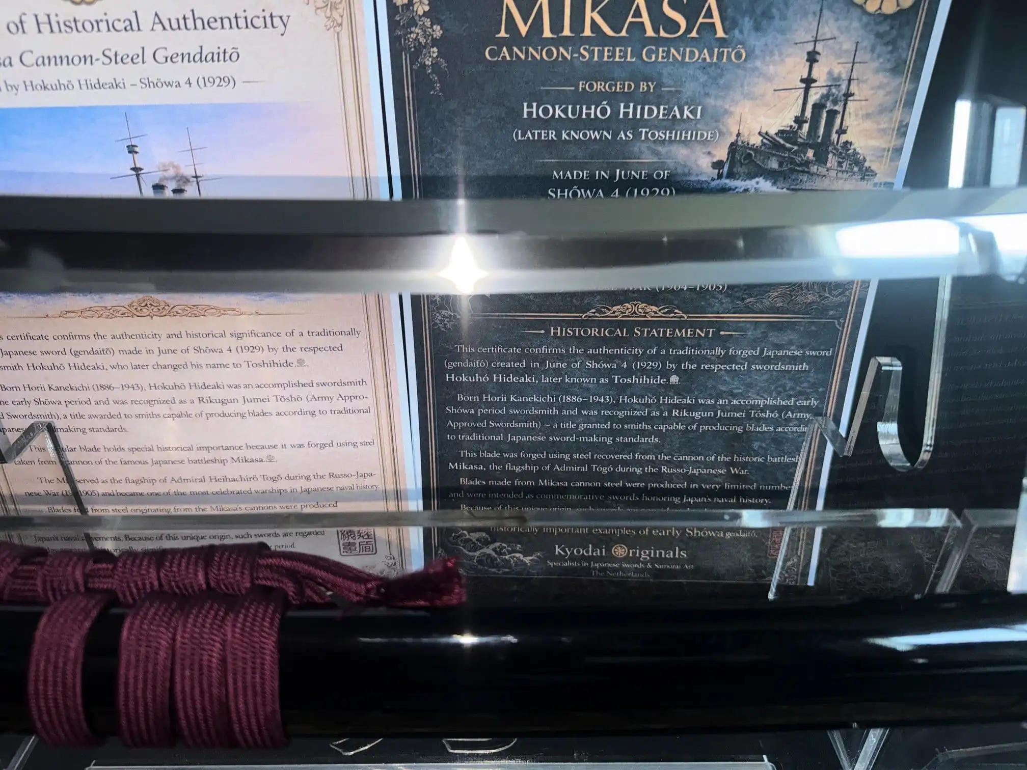 Gendaitō Battleship Mikasa katana blade reflecting historical certificate, Tsuka wrapped in deep red silk