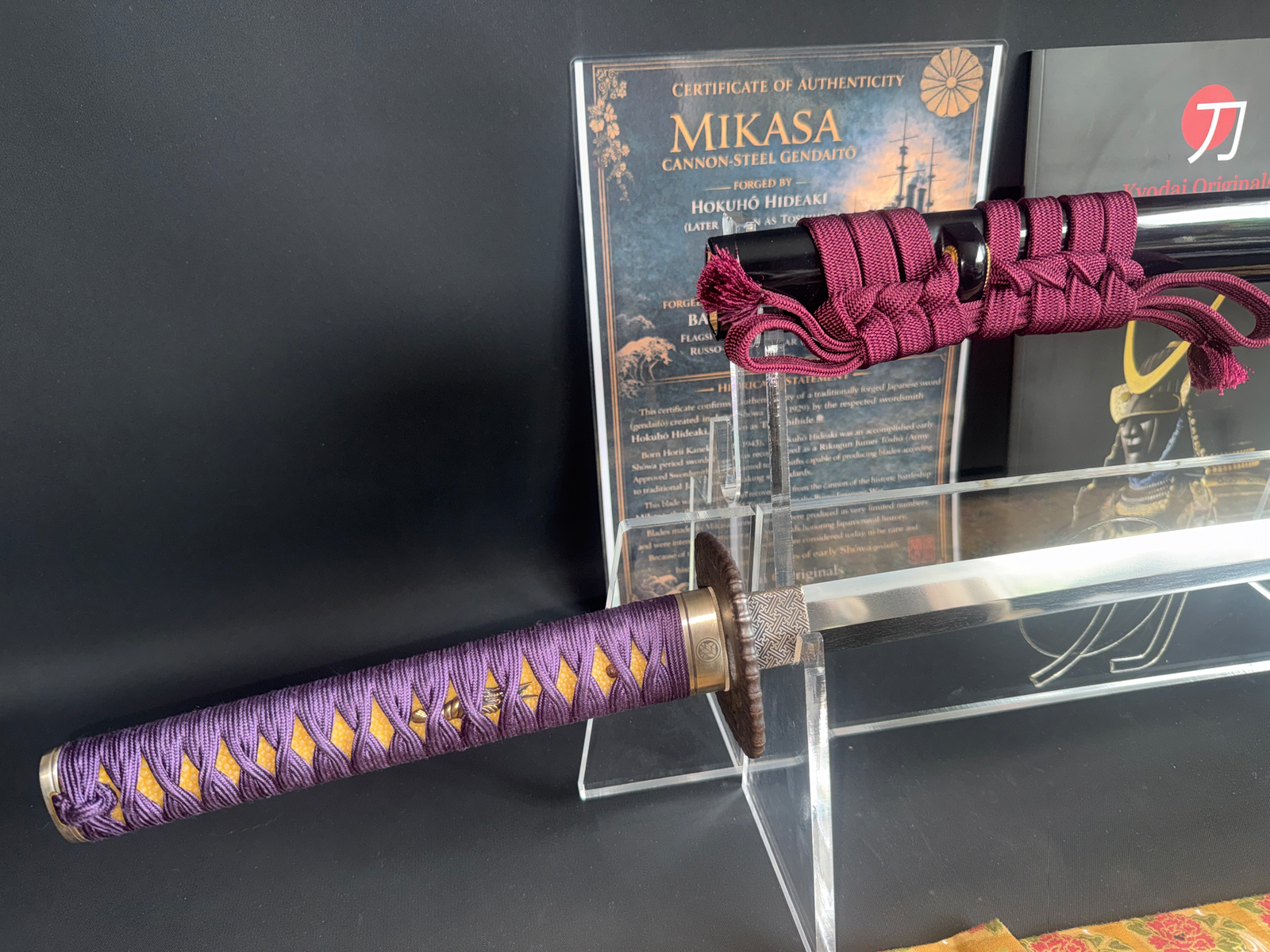 Katana Gendaito Battleship Mikasa with purple tsuka and red saya against certificate and black background
