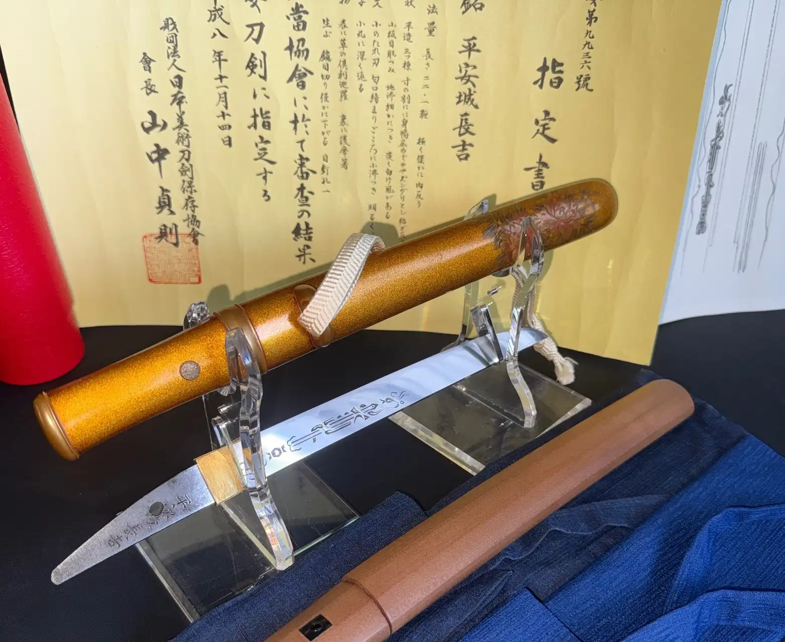 NBTHK Jūyō Tōken Tantō by Heianjō Nagayoshi with gold scabbard displayed against certification