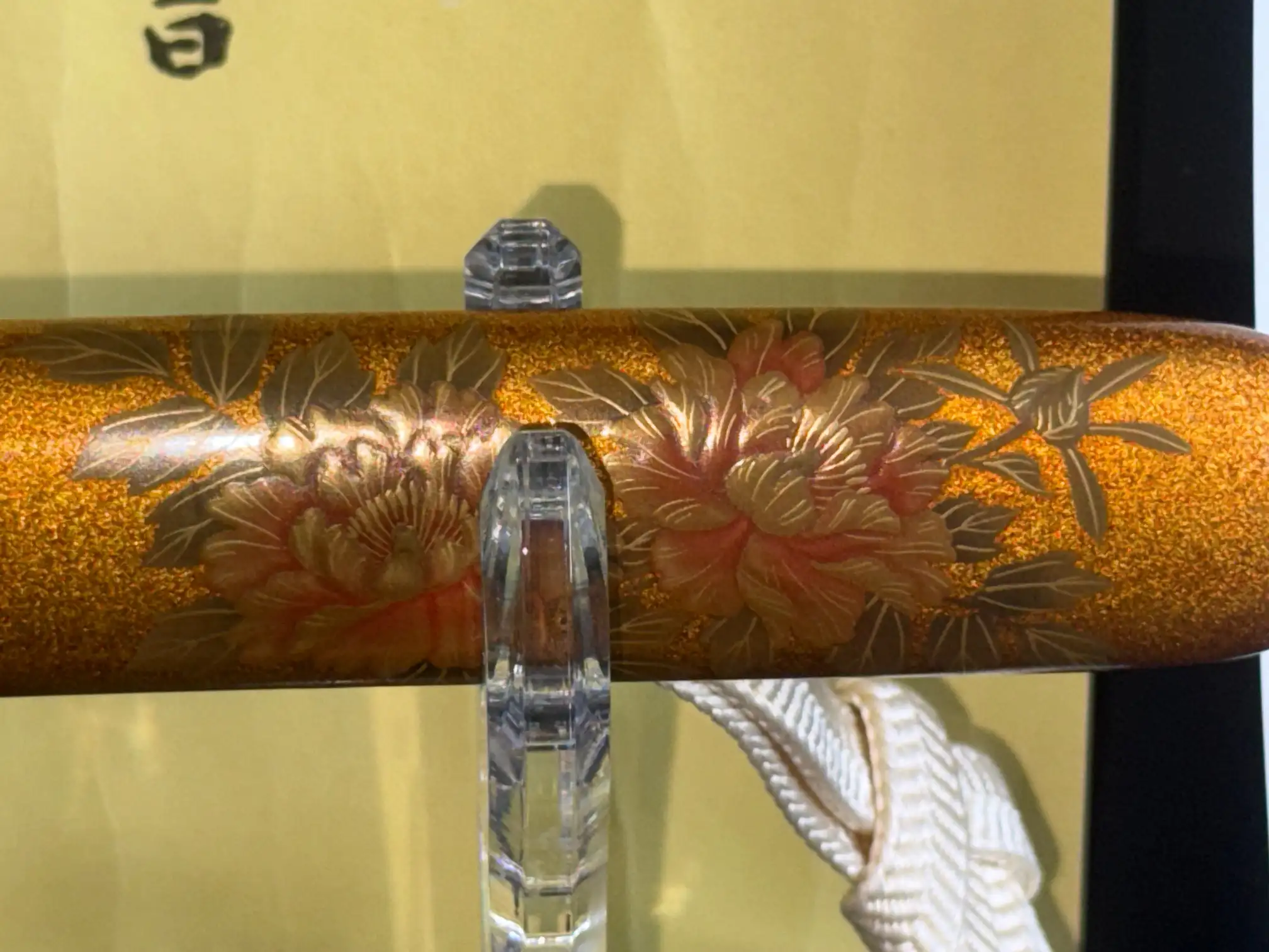 Close-up of the scabbard of an NBTHK Jūyō Tōken Tantō by Heianjō Nagayoshi, showing golden floral motifs
