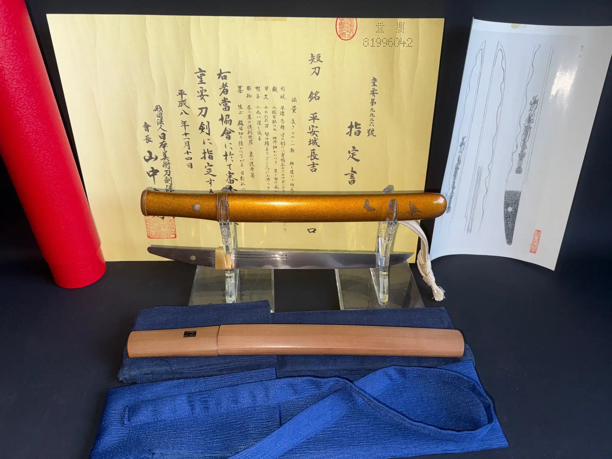 NBTHK Jūyō Tōken Tantō by Heianjō Nagayoshi, with saya and certificate, displayed angled atop blue cloth