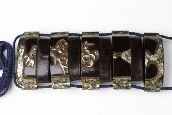 Dark Edo Japanese Inro accessory with intricate floral engravings and mother-of-pearl inlay, viewed from above.