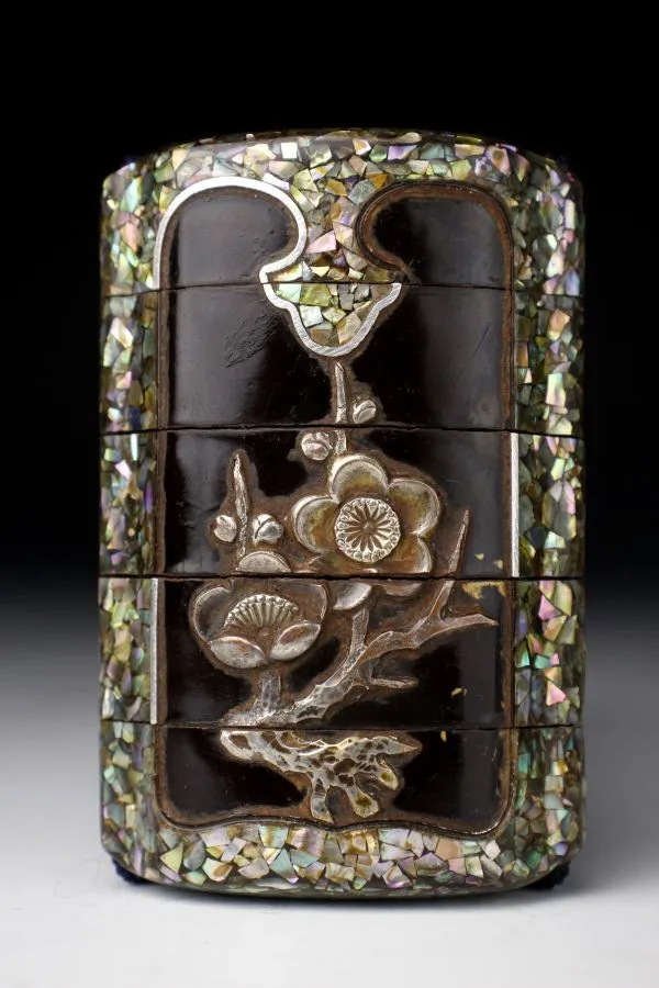 Edo Japanese Inro accessory, dark lacquer with mother-of-pearl inlay and silver blossoms viewed from an angle