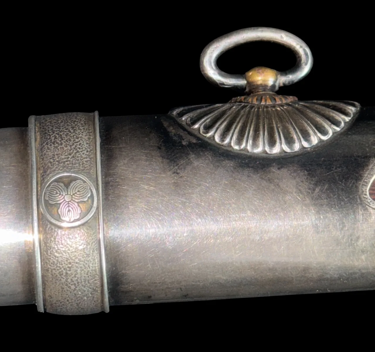 Close-up of Silver Skull Tantō by Ryūjin Minamoto Sadakazu saya, showing decorative kashira and silver fittings.