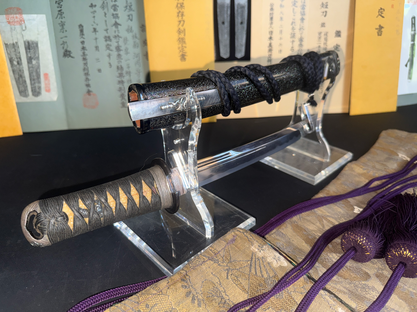 Kawachi no Kami Hironobu Tantō, close-up of blade and hilt on stand, Imperial Kikumon detail visible.