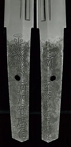 Close-up of Kawachi no Kami Hironobu Tantō Imperial Kikumon tang, carved with inscriptions and floral design.
