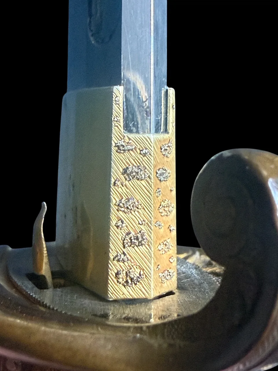 Kyū-Guntō katana close-up, showing detailed gilded fuchi and tang base of Gassan School Nihontō blade