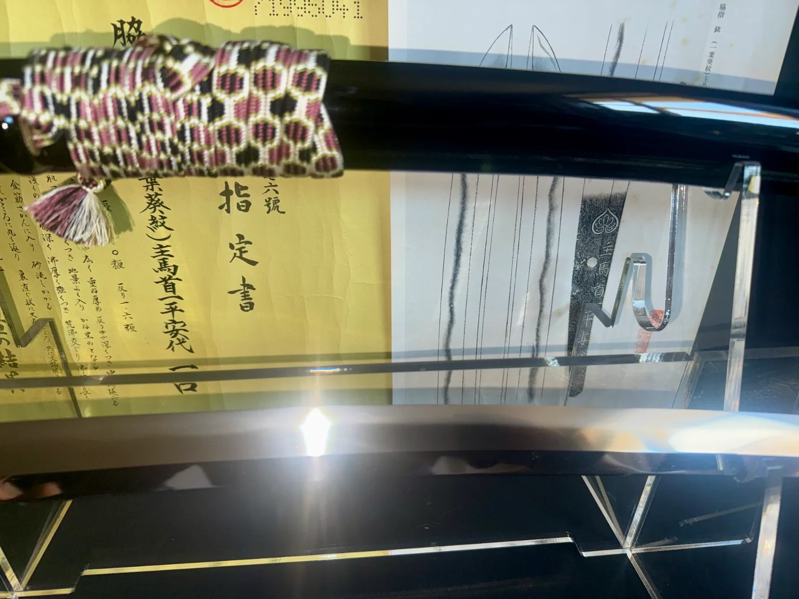 Jūyō Tōken Wakizashi by Shume no Kami Ippei Yasuyo with Tokugawa Aoi Crest, blade against Japanese documents