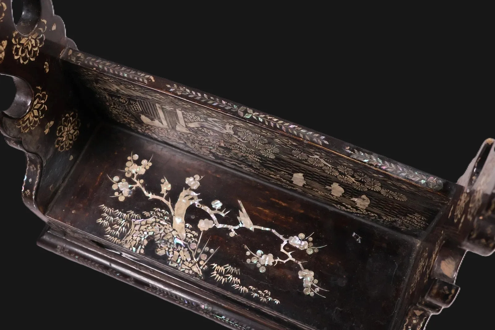 Close-up of Antique Japanese Katana Kake Accessories, mother-of-pearl inlay birds and plum blossoms on dark wood.