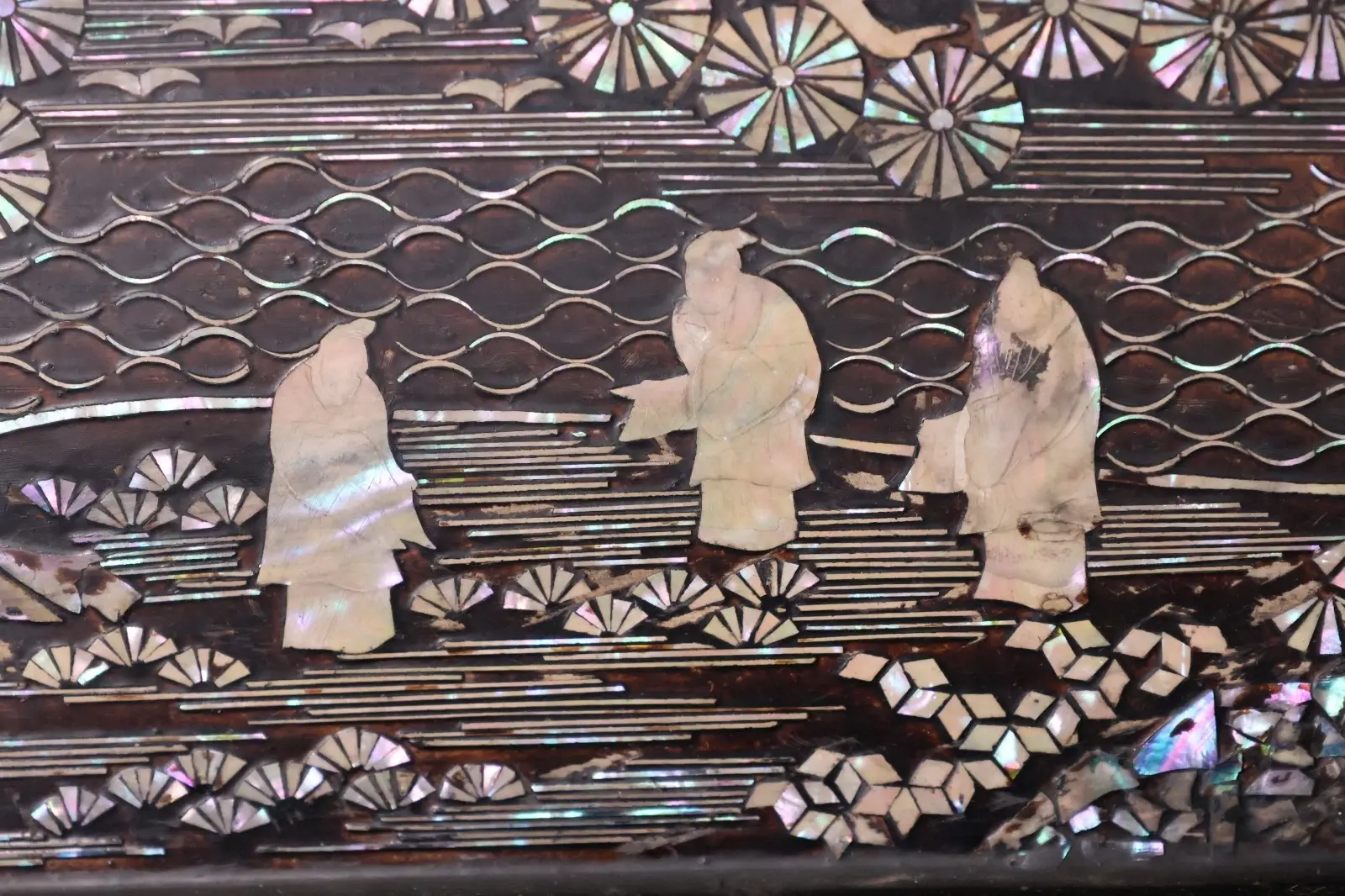 Close-up of raden inlay on antique Japanese Silver Katana Kake, showing three figures and water motifs. Accessories.