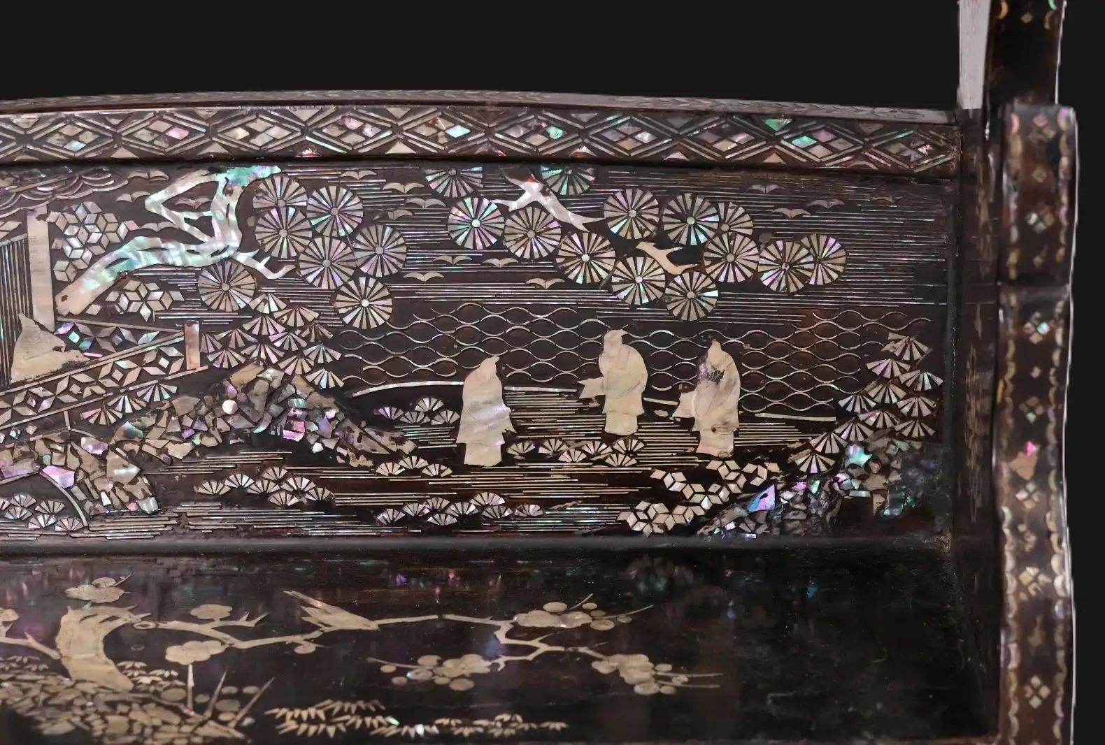 Close-up of raden inlay on antique Japanese Silver Katana Kake showing figures, trees, and birds, Meiji Period accessory.