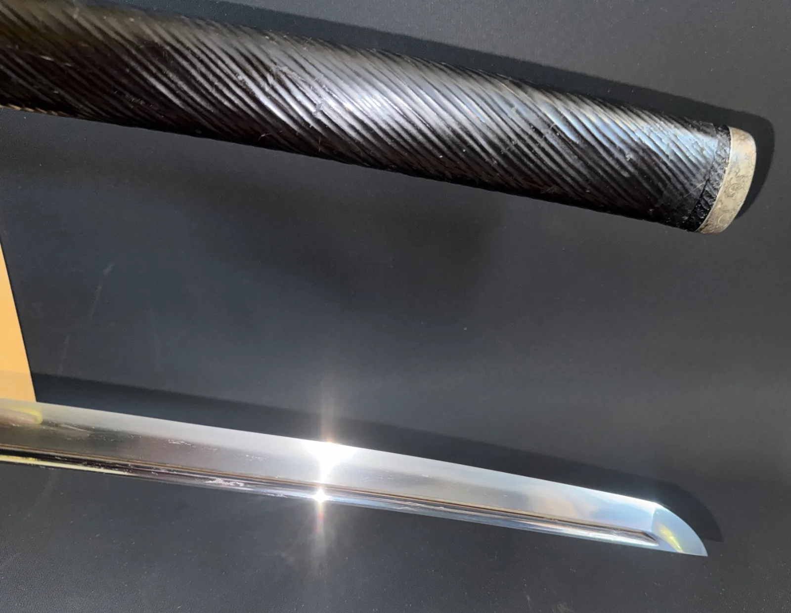 Close-up of a Kamakura Katana Rai Kunizane Tokubetsu Hozon katana showing its shiny blade and black handle.