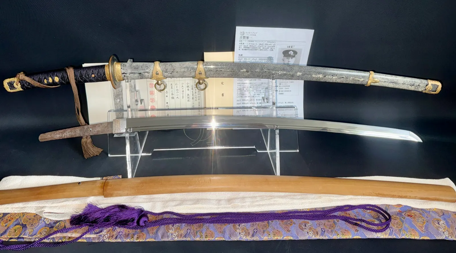 Naval Commissioned Gendaitō katana by Sadashige Gassan, hilt and blade visible with documents and scabbard.