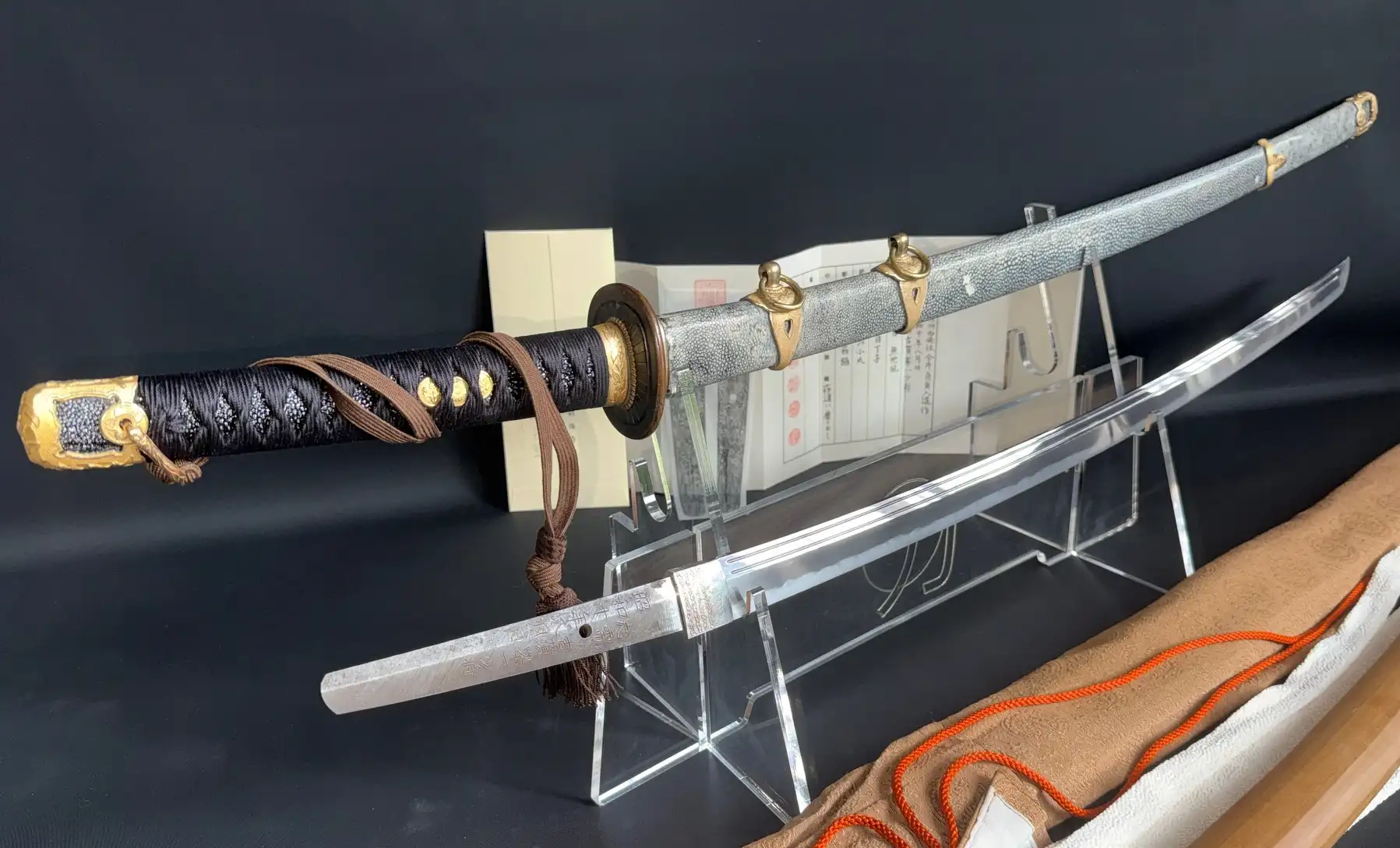 Naval Gendaitō katana by Sadashige Gassan, blade and black wrapped handle with golden accents visible.