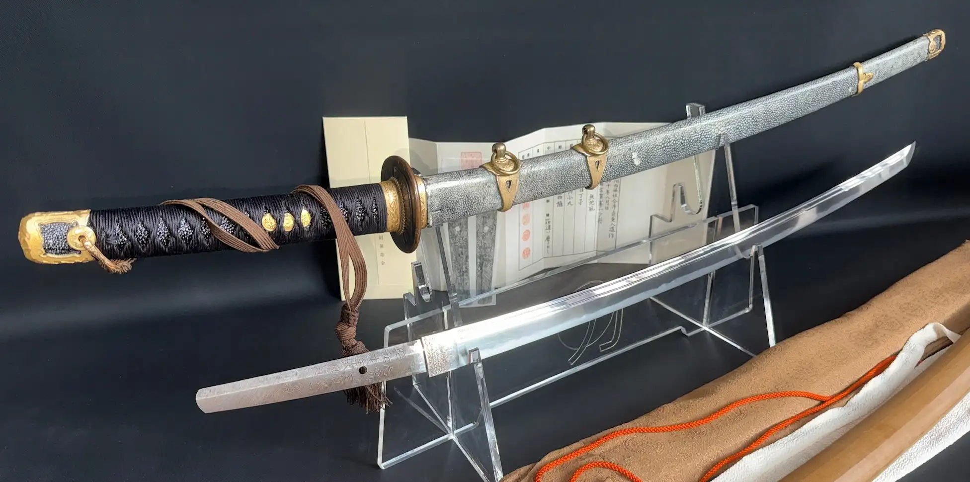 Naval Commissioned Gendaitō katana by Sadashige Gassan, hilt and scabbard with exposed blade on display.