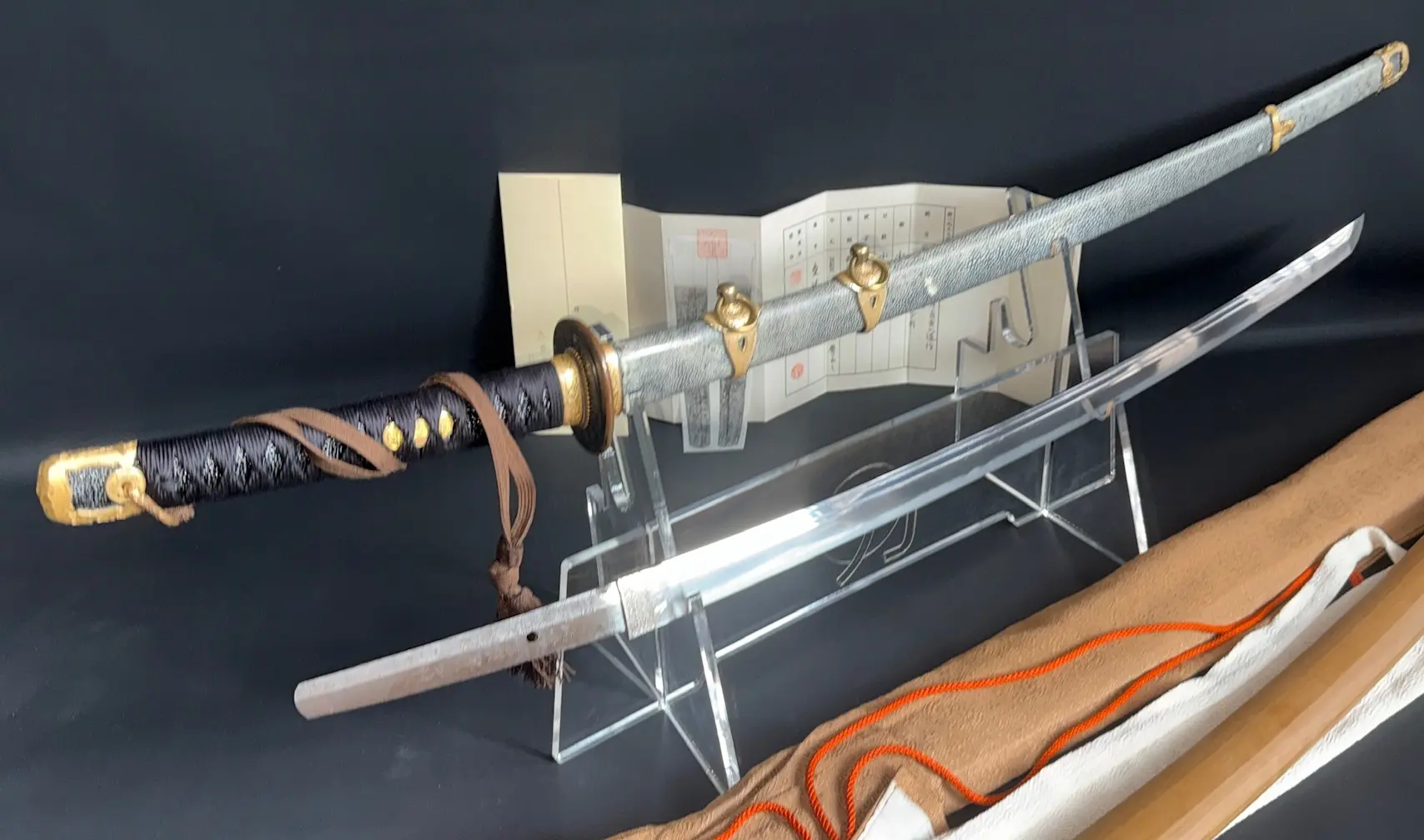 Kyodai Originals Gendaitō katana by Sadashige Gassan, with a long blade and dark tsuka, displayed with its scabbard.