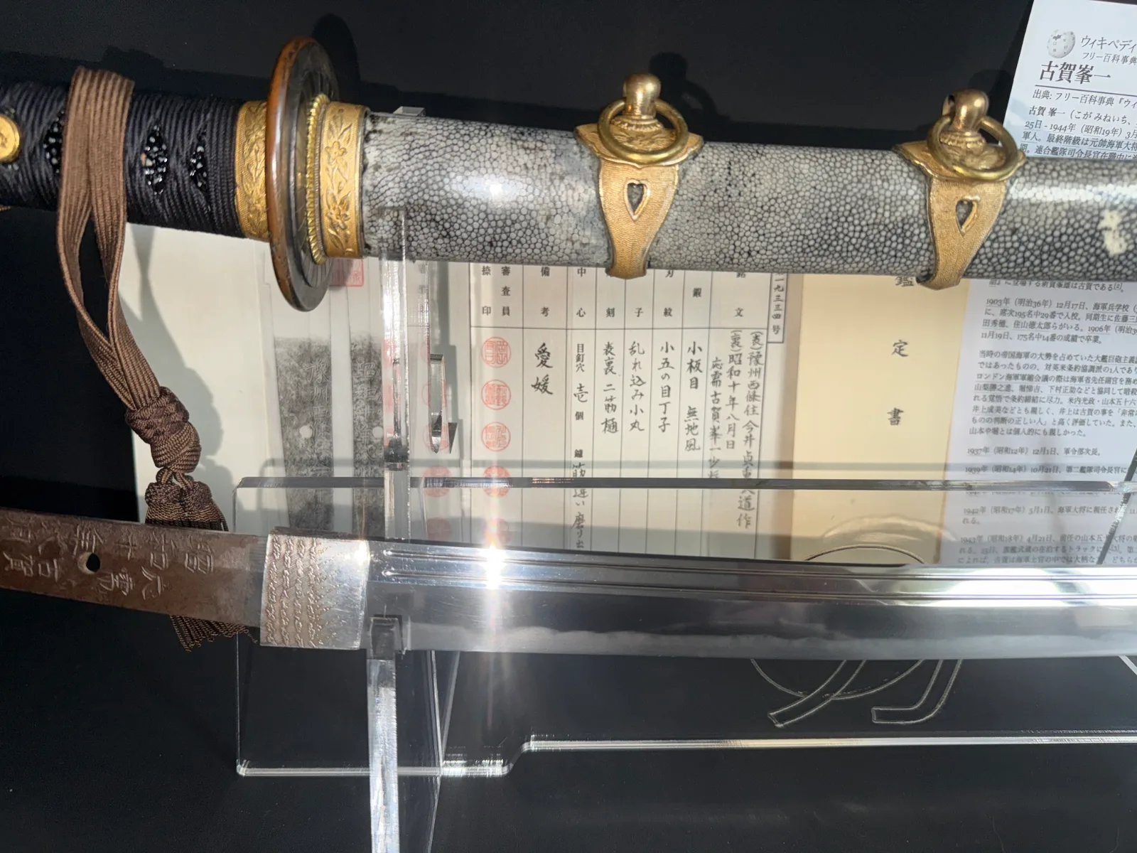 Naval Commissioned Gendaitō katana close-up showing hilt, scabbard fittings, and shiny blade.