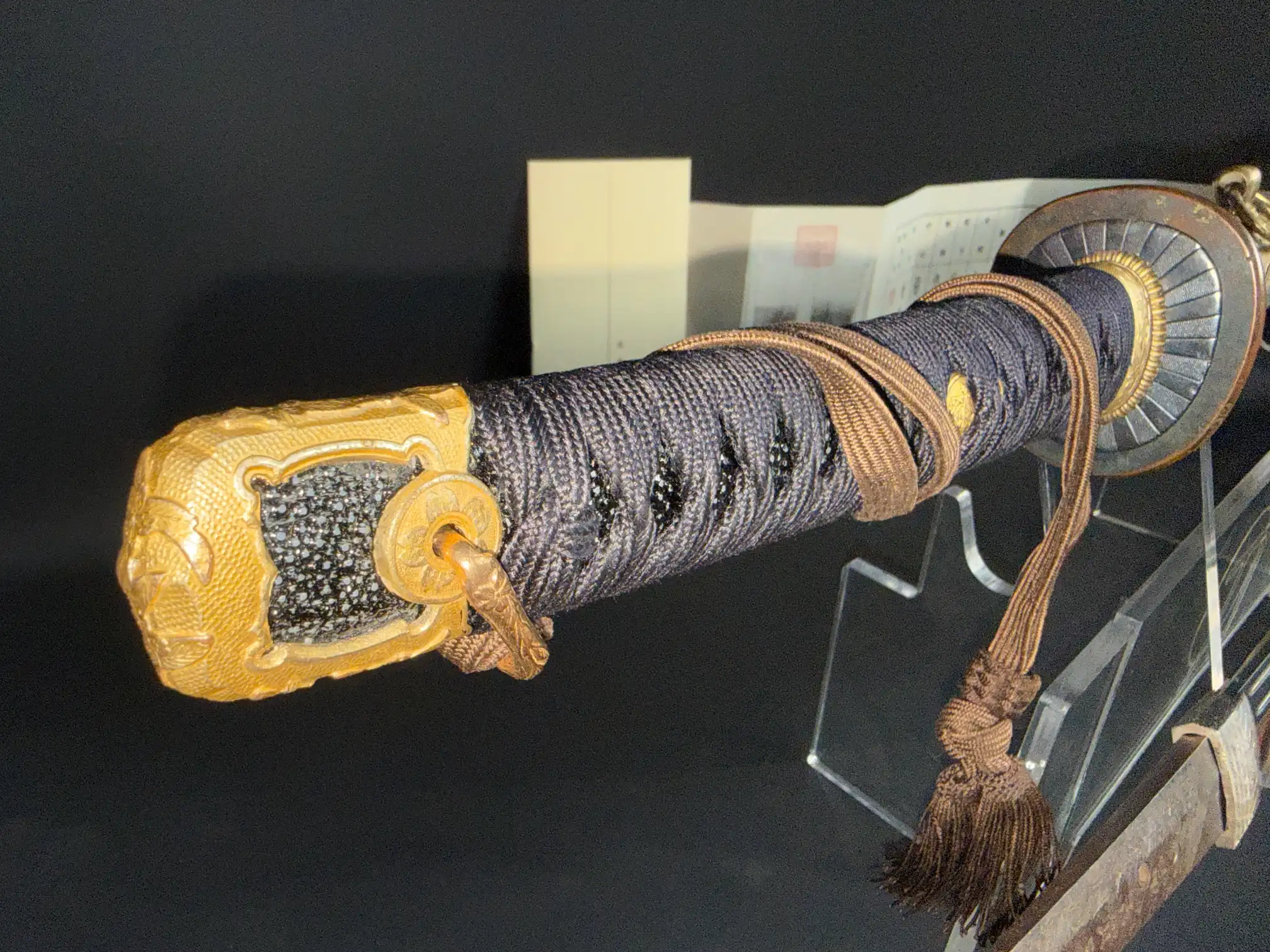 Naval Commissioned Gendaitō katana by Sadashige Gassan, close-up of dark hilt wrapping, gold pommel, and brown cord