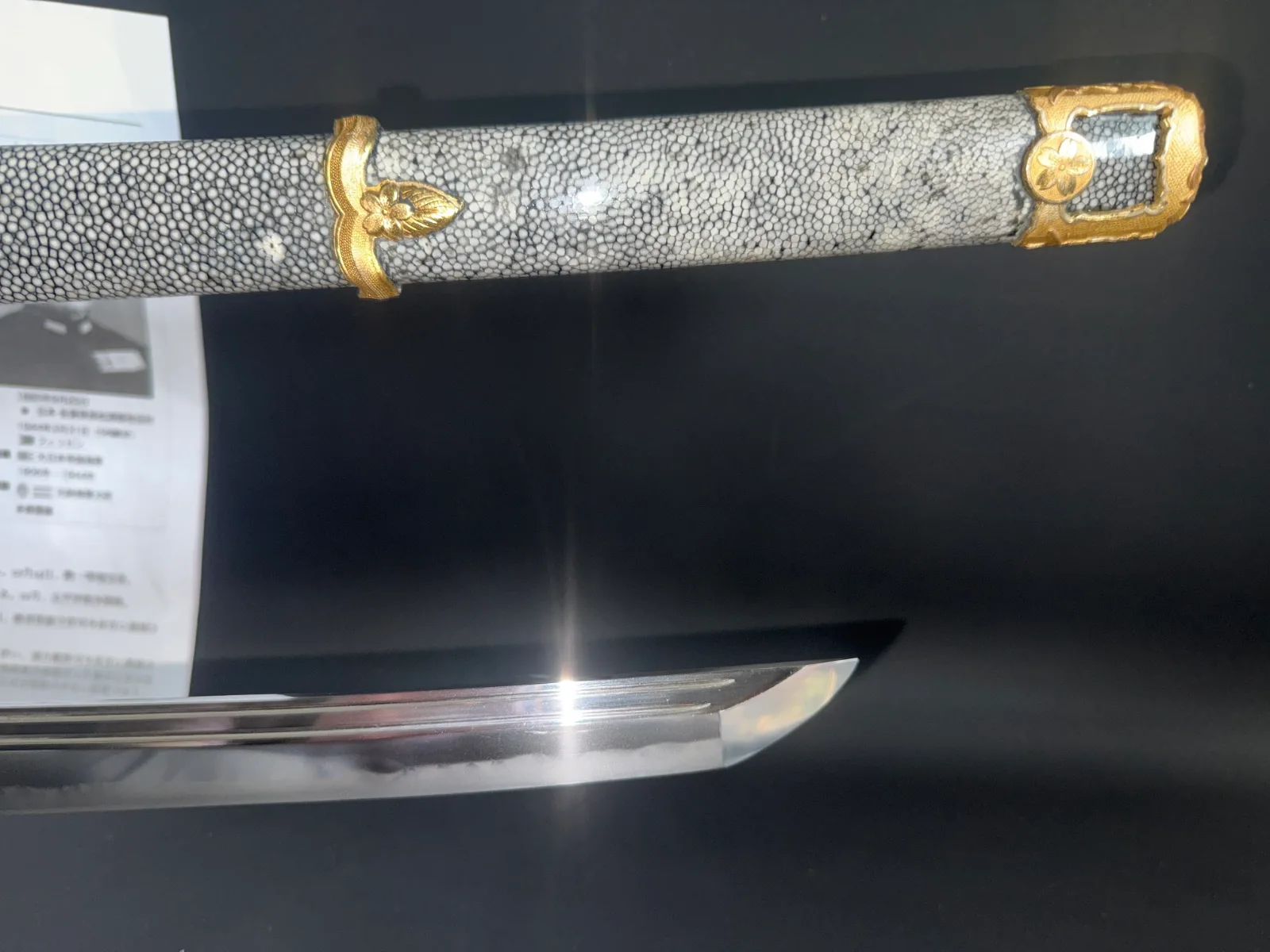 Close-up of a Naval Commissioned Gendaitō katana by Sadashige Gassan, showing ray skin hilt and polished blade tip.