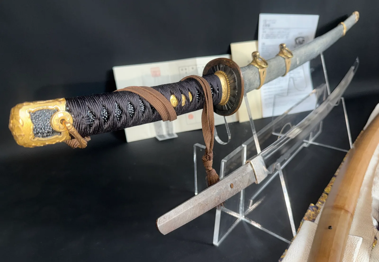 Naval Commissioned Gendaitō katana by Sadashige Gassan, close-up of handle and partially unsheathed blade.