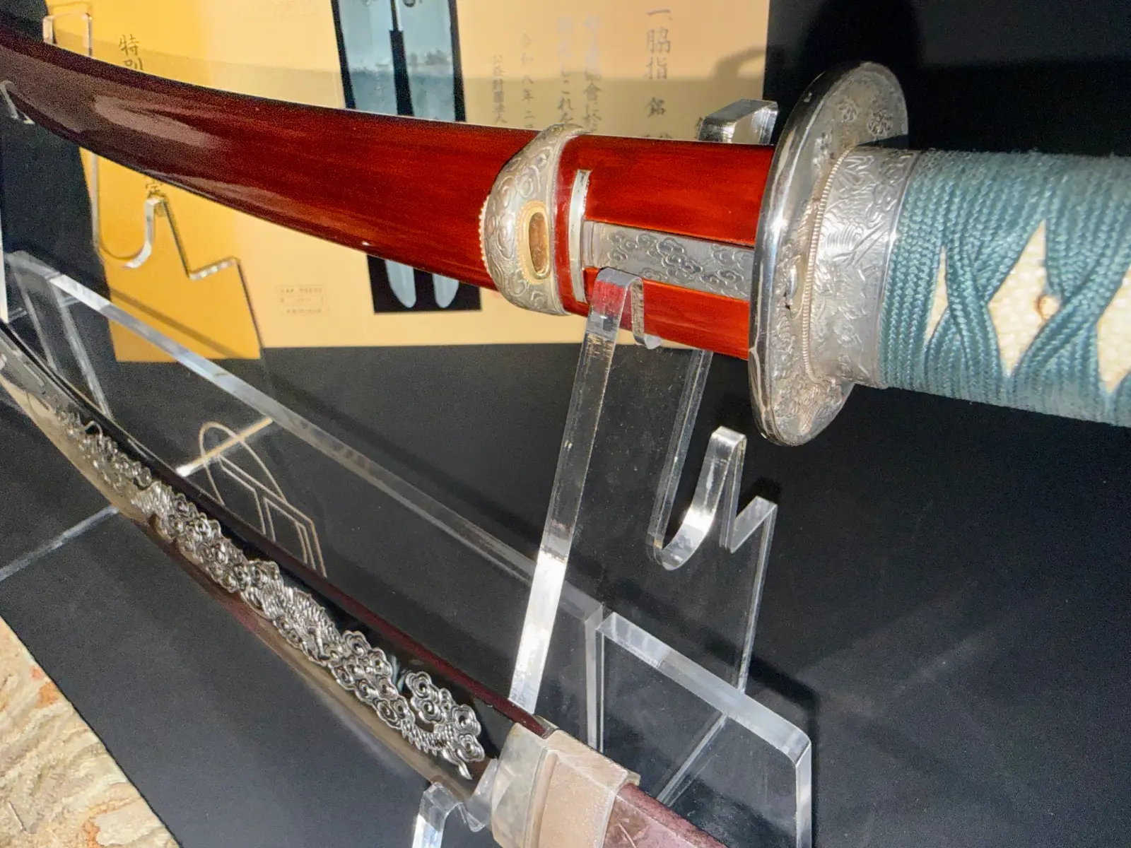 Suishinshi Masahide Wakizashi, close-up of blade and hilt with red scabbard, on display stand