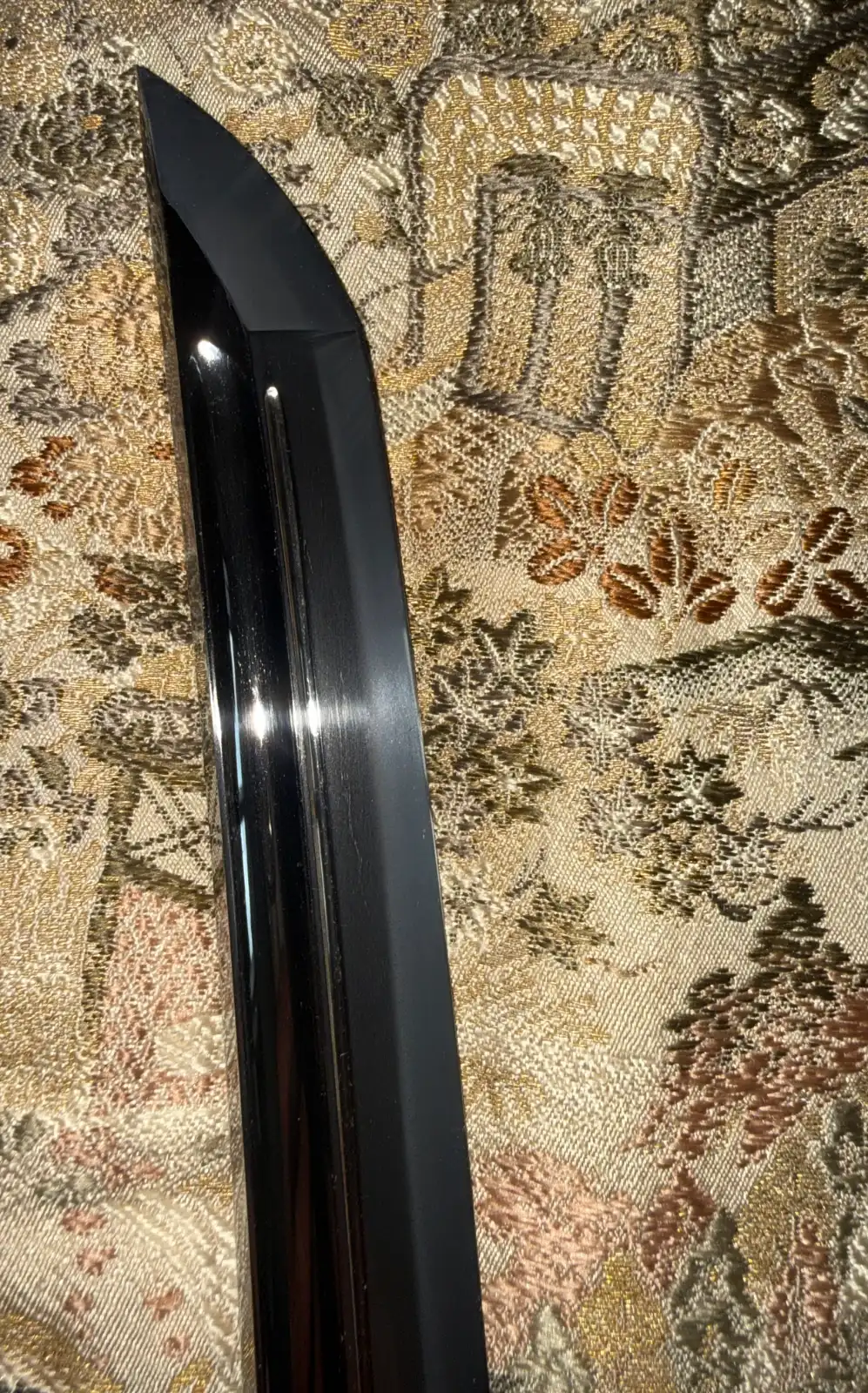 Close-up of the polished blade of a Suishinshi Masahide Wakizashi NBTHK Tokubetsu Hozon, resting on patterned fabric