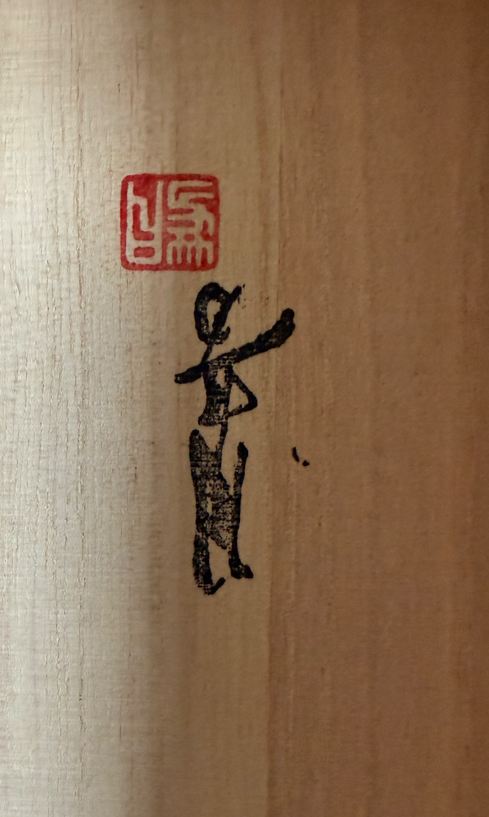 Detail of artist's red seal and black ink calligraphy on light wood surface for Takaoka Bronze Kōro ACCESSORIES.