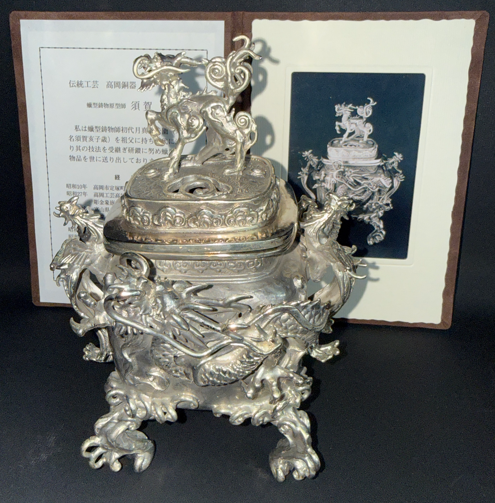 Ornate silver Takaoka Bronze Kōro ACCESSORIES, top-down angle, featuring detailed dragon and kirin motifs.