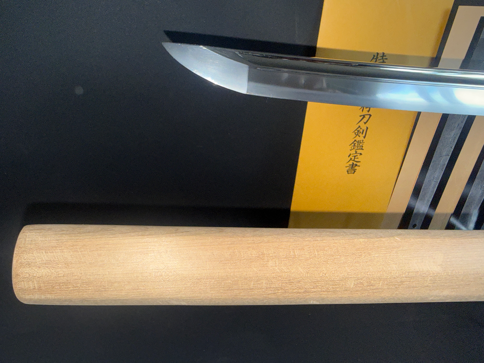 Close-up of the polished blade tip (kissaki) of a Japanese Masterpiece Katana by Gassan Sadakazu, with shirasaya and NBTHK document.
