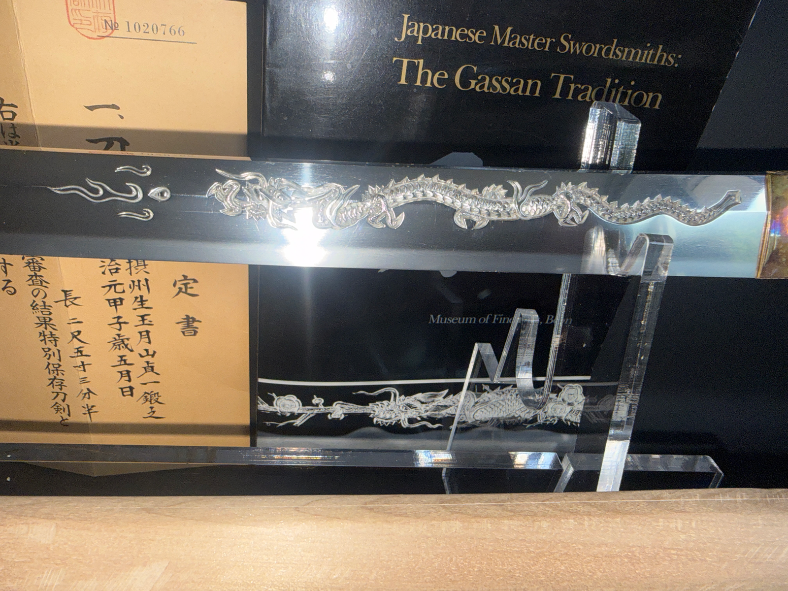 Japanese Masterpiece Katana by Gassan Sadakazu with intricate dragon horimono on the blade, a displayed antique katana