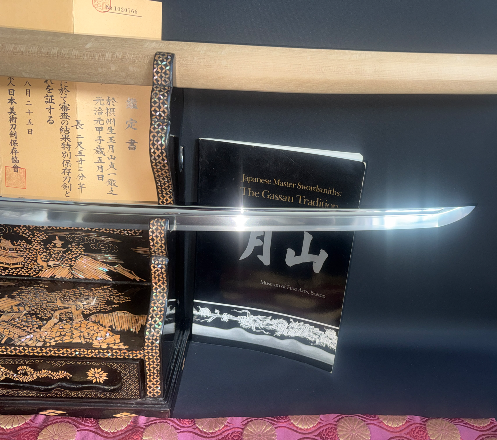 Japanese Masterpiece Katana by Gassan Sadakazu blade resting on an elaborate stand with certificate and book