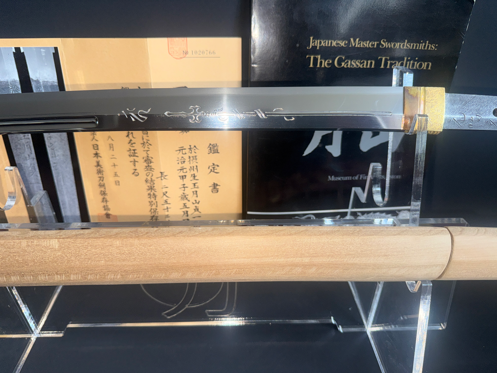 Japanese Masterpice Katana by Gassan Sadakazu with intricate horimono on blade, documents, and book