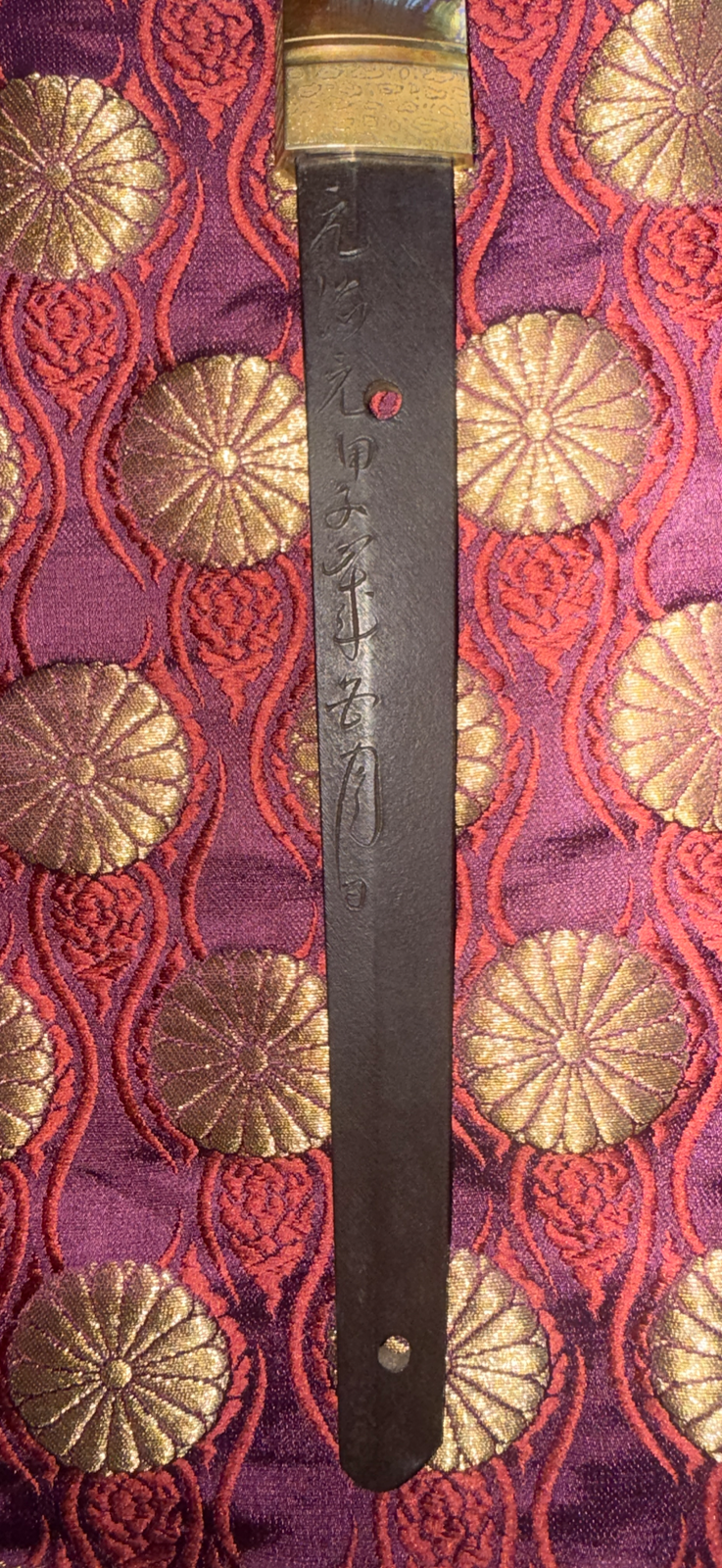 Gassan Sadakazu NBTHK Tokubetsu Hozon katana tang with mei inscriptions visible against rich brocade fabric