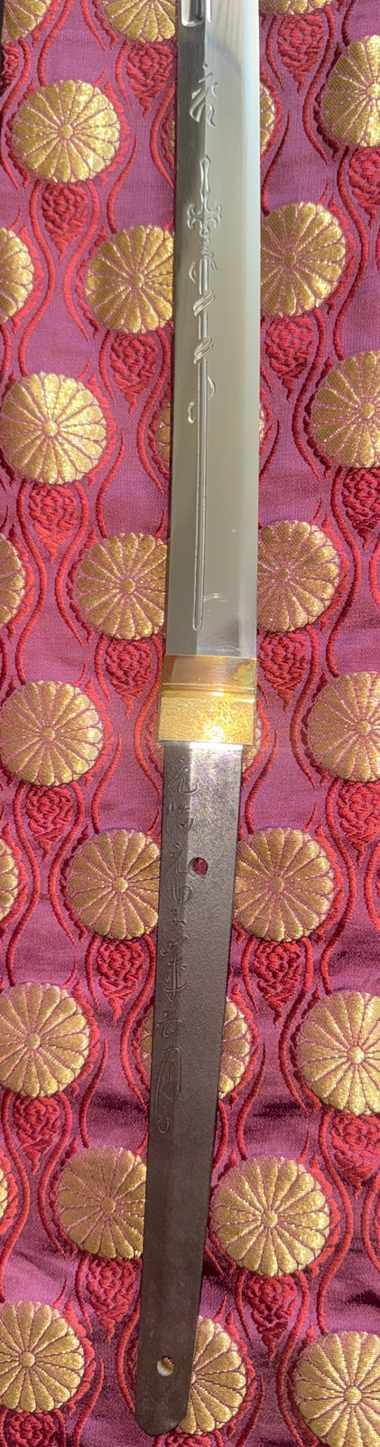 Japanese Masterpiece Katana by Gassan Sadakazu with horimono, visible nakago, and mei against a vibrant red fabric.