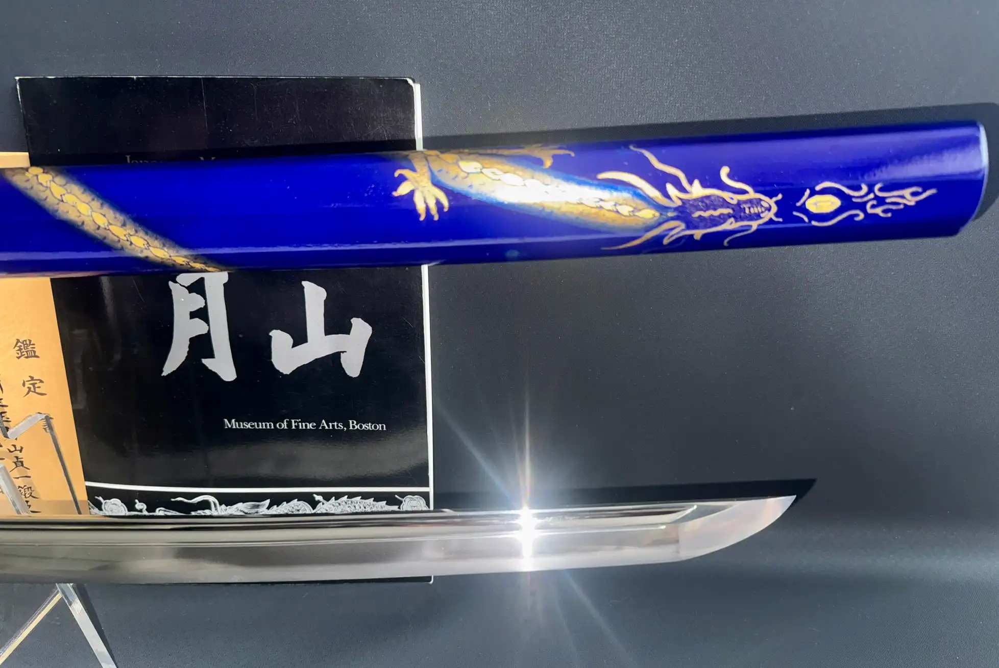 Top view of a Gassan Sadakazu NBTHK Tokubetsu Hozon katana with blue saya and golden dragon motif