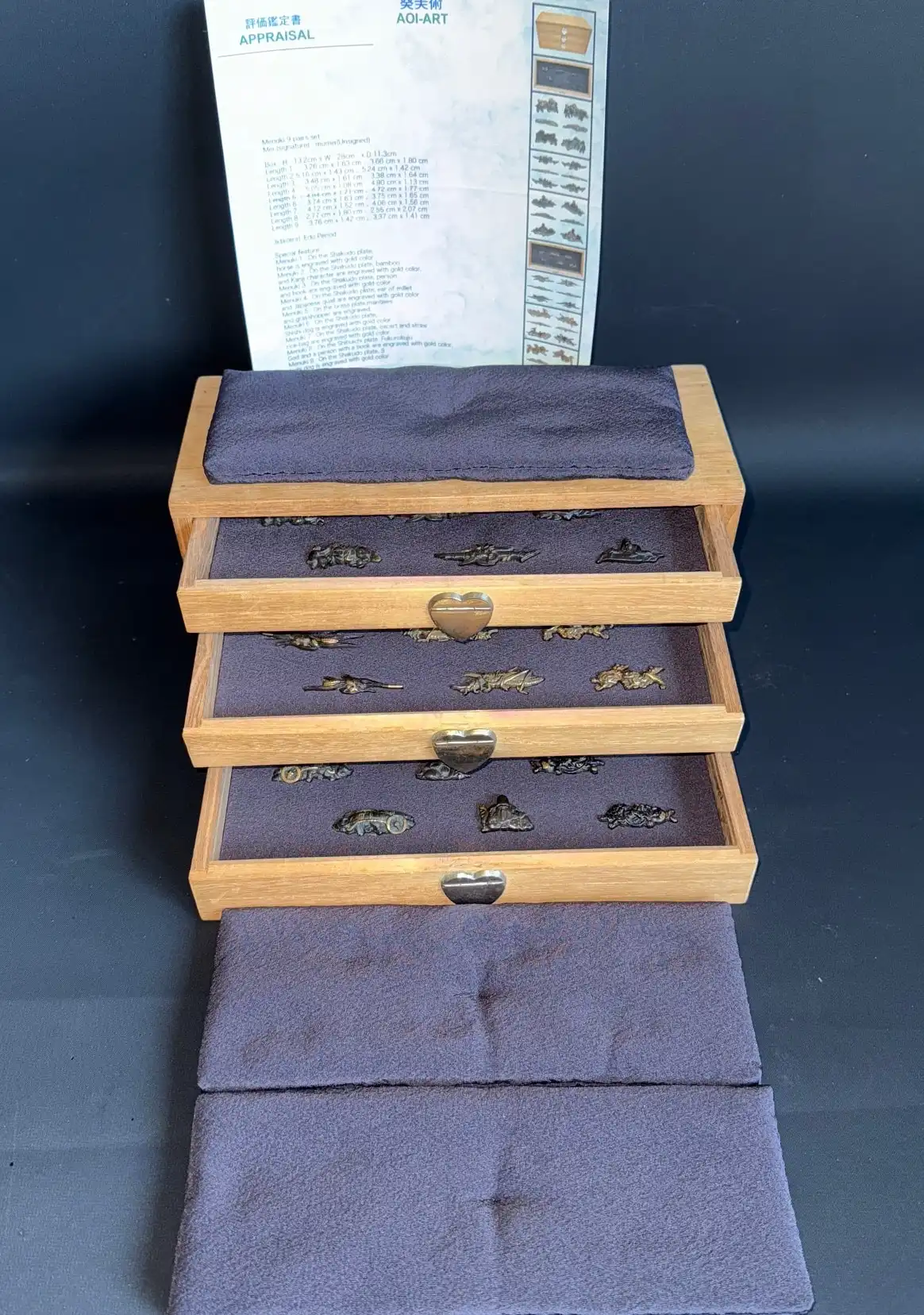Front view of 9 pairs Edo period Menuki sword accessories in open Kiri box with appraisal document
