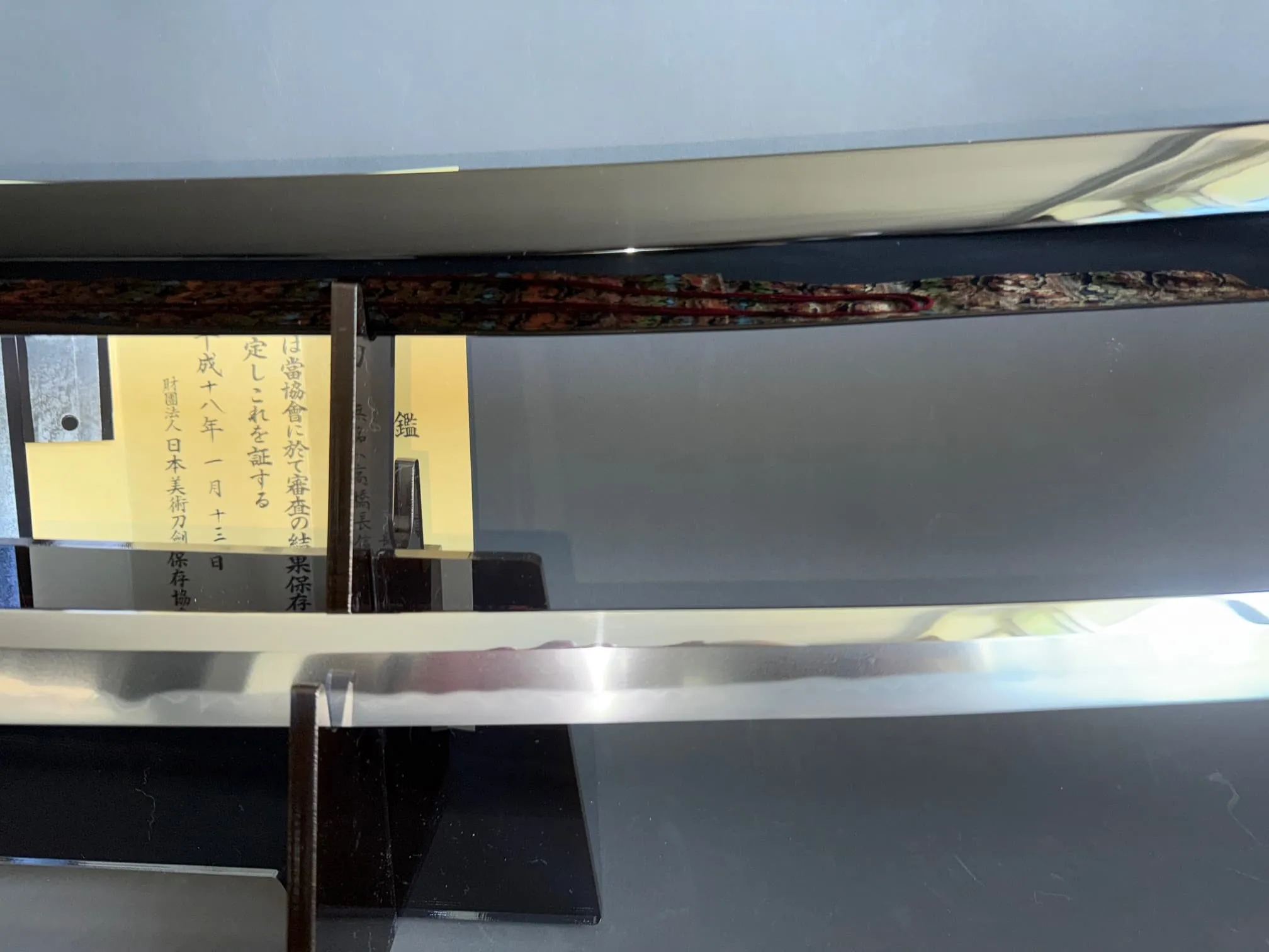 Close-up of Jinja Hōnō Tachi Naganobu Katana blade and scabbard, with Japanese documentation