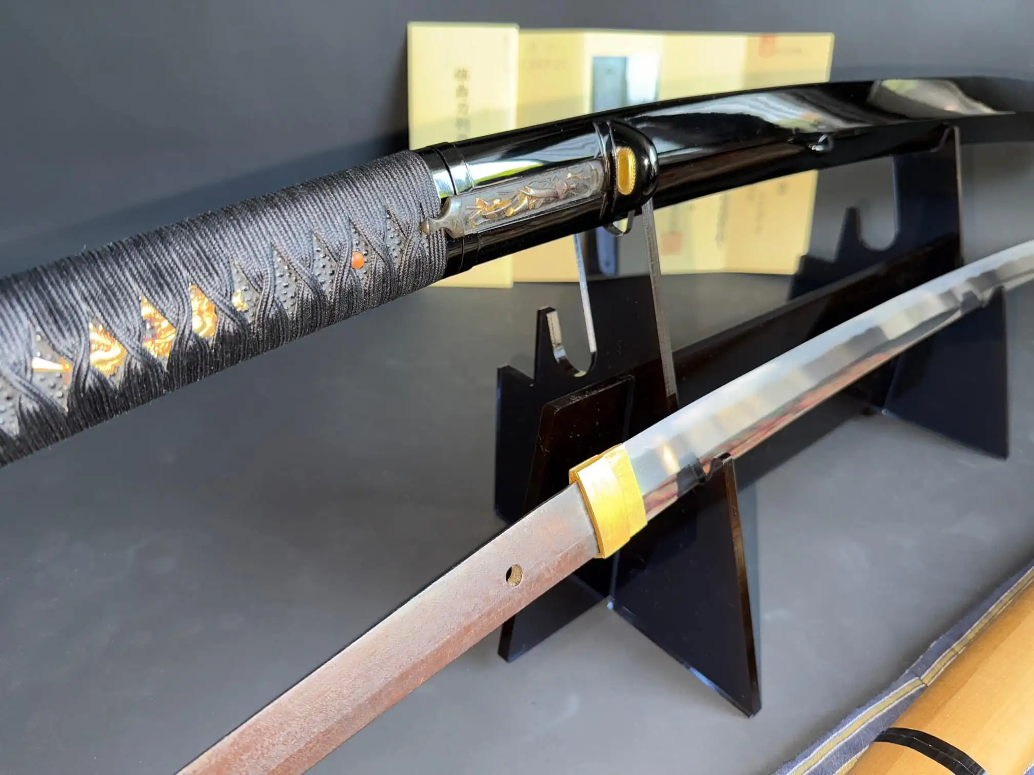 Jinja Honō Tachi Naganobu Katana with partially drawn blade, showing ornate tsuka and plain tang