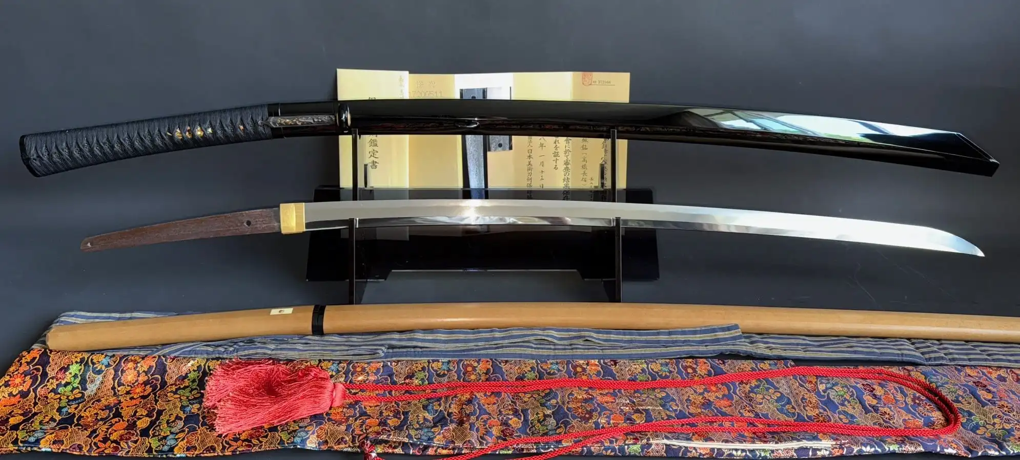 Kyodai Originals Jinja Hōno Tachi Naganobu Katana with glossy black scabbard, presented on a stand