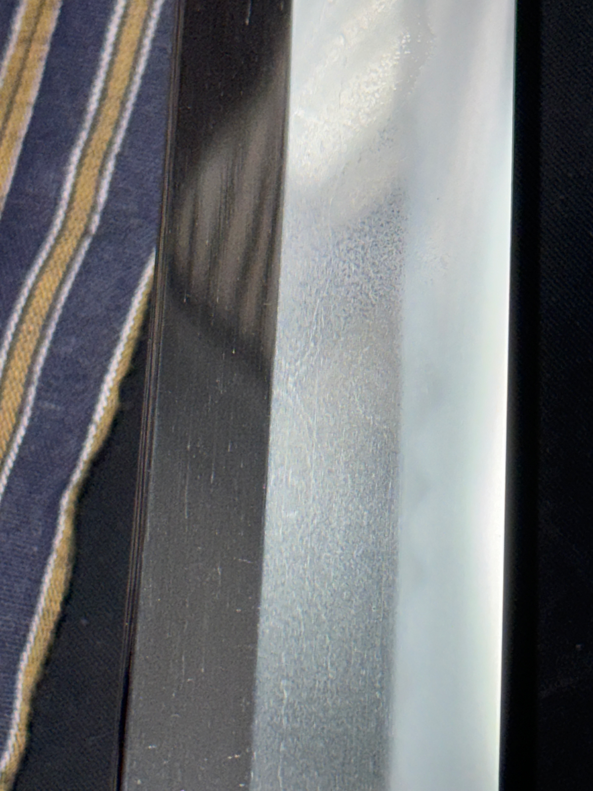 Close-up of Jinja Hōnō Tachi Naganobu katana blade showing delicate jitetsu grain and hamon detail