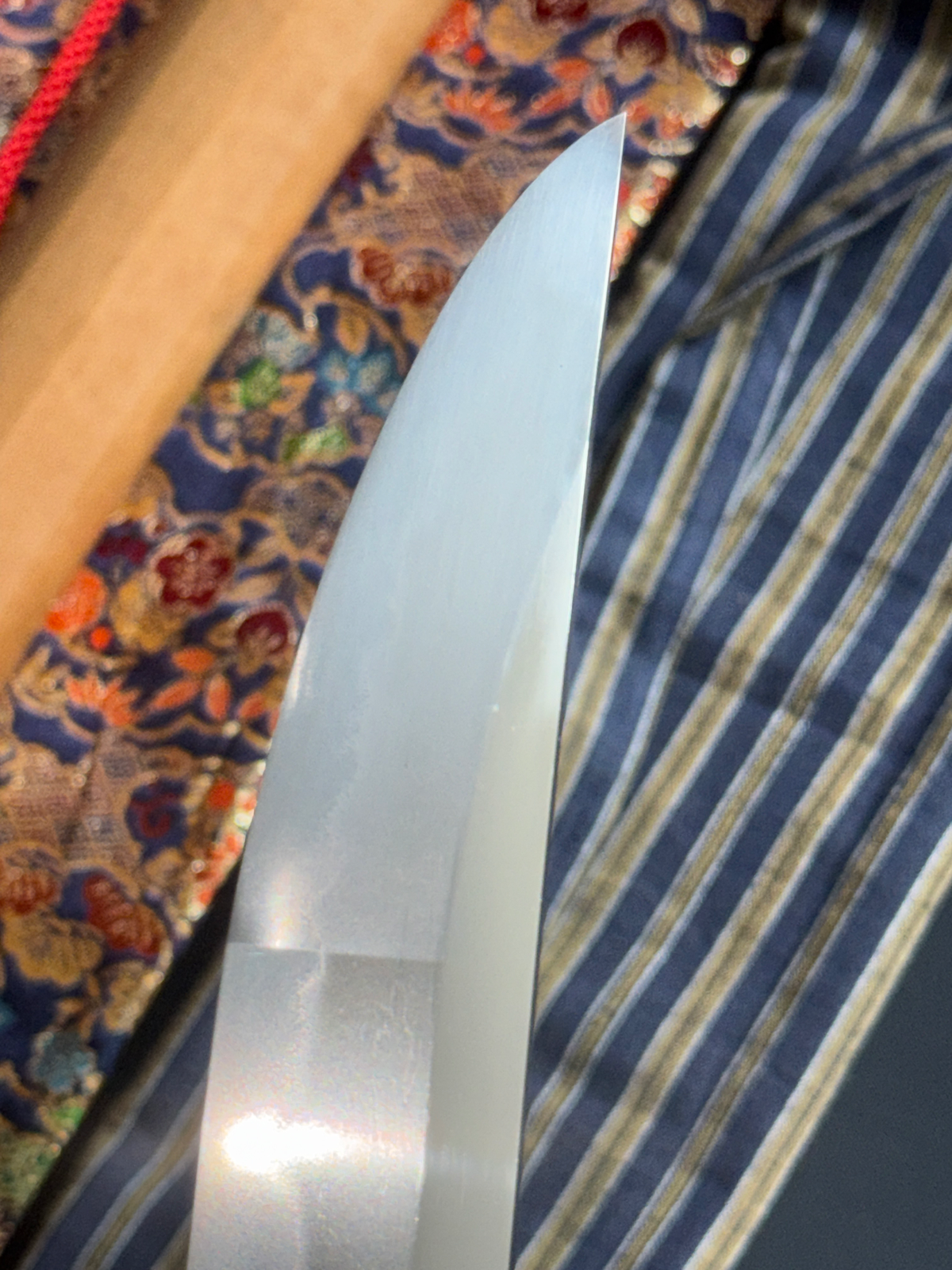 Close-up of the polished blade tip of a Jinja Hōnō Tachi Naganobu Katana with reflections