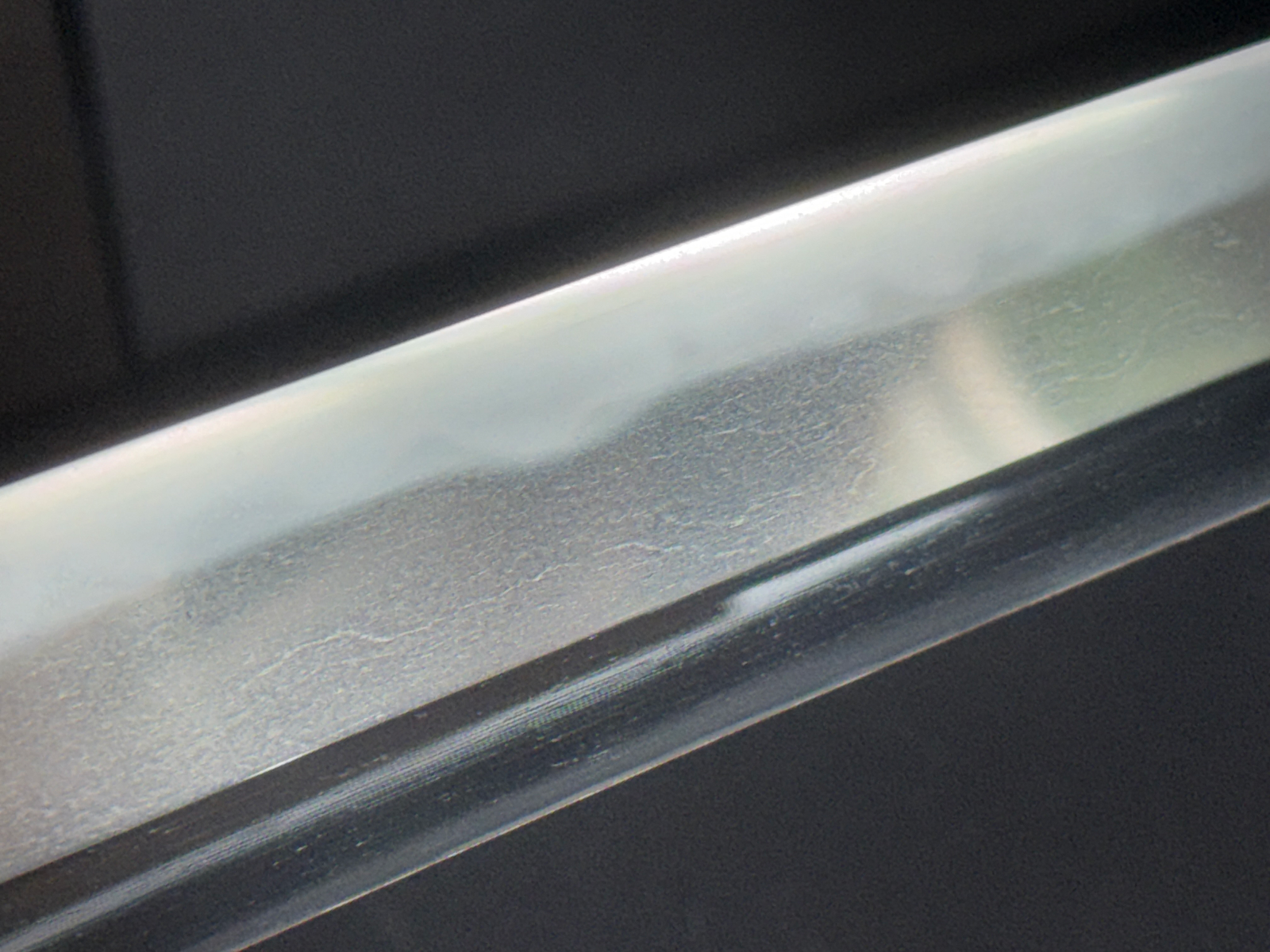 Close-up of Jinja Hōnō Tachi Naganobu katana blade showing hamon and surface details from Kyodai Originals