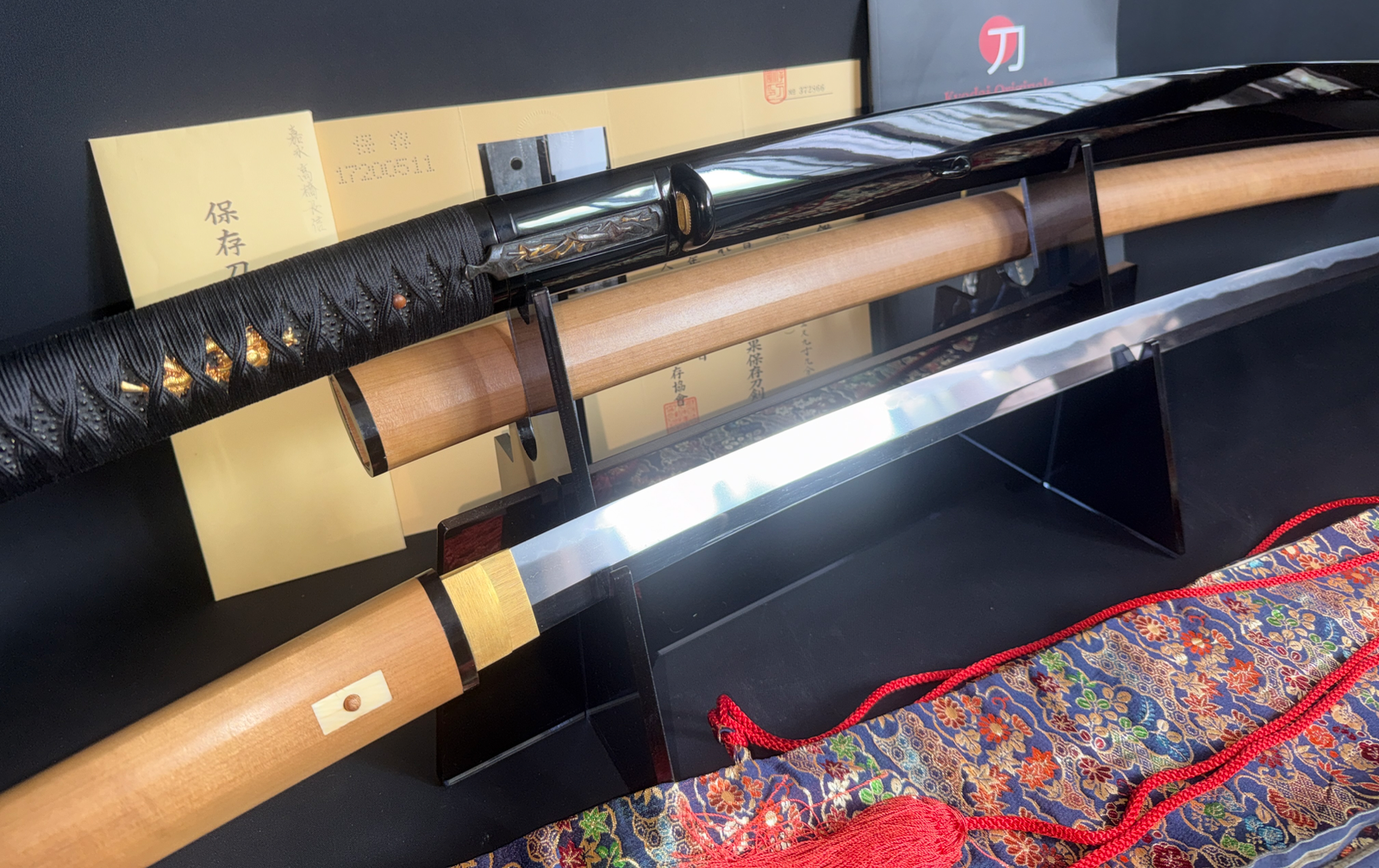 Jinja Hōnō Tachi Naganobu Katana with glossy black saya, polished blade, and wooden shirasaya in display.