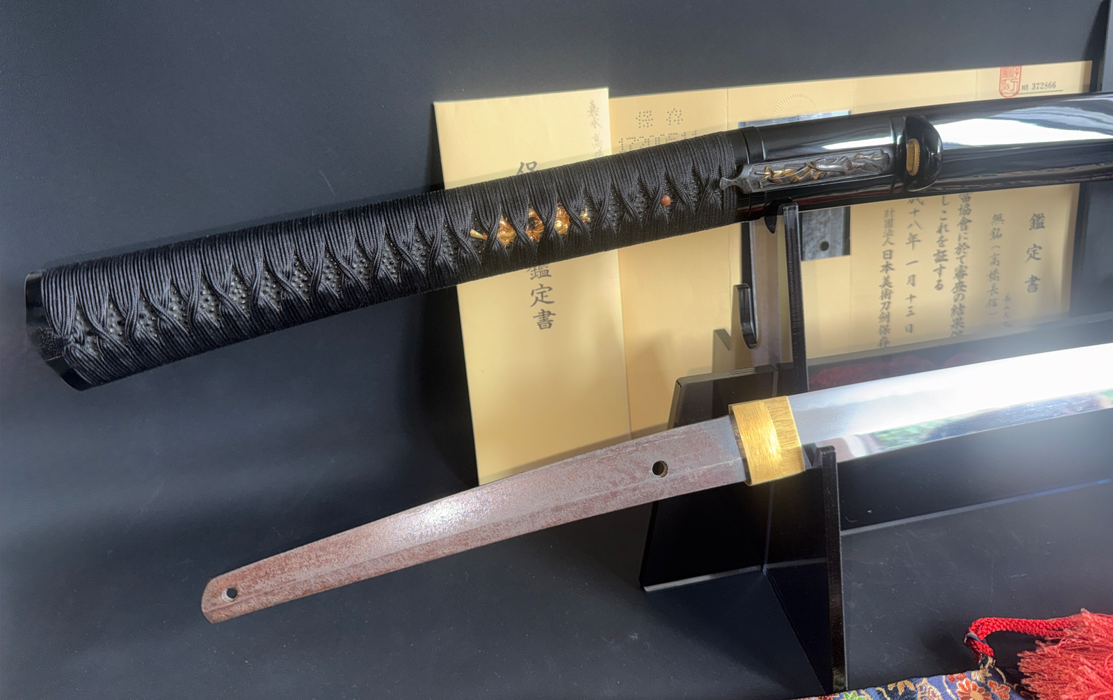 Close-up of Jinja Hōnō Tachi Naganobu katana hilt, showing ray skin and cord wrap, blade partially visible