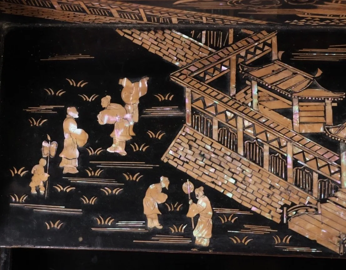 Close-up of a Katana Kake with intricate raden inlay showing figures and architecture, a Meiji-period antique.