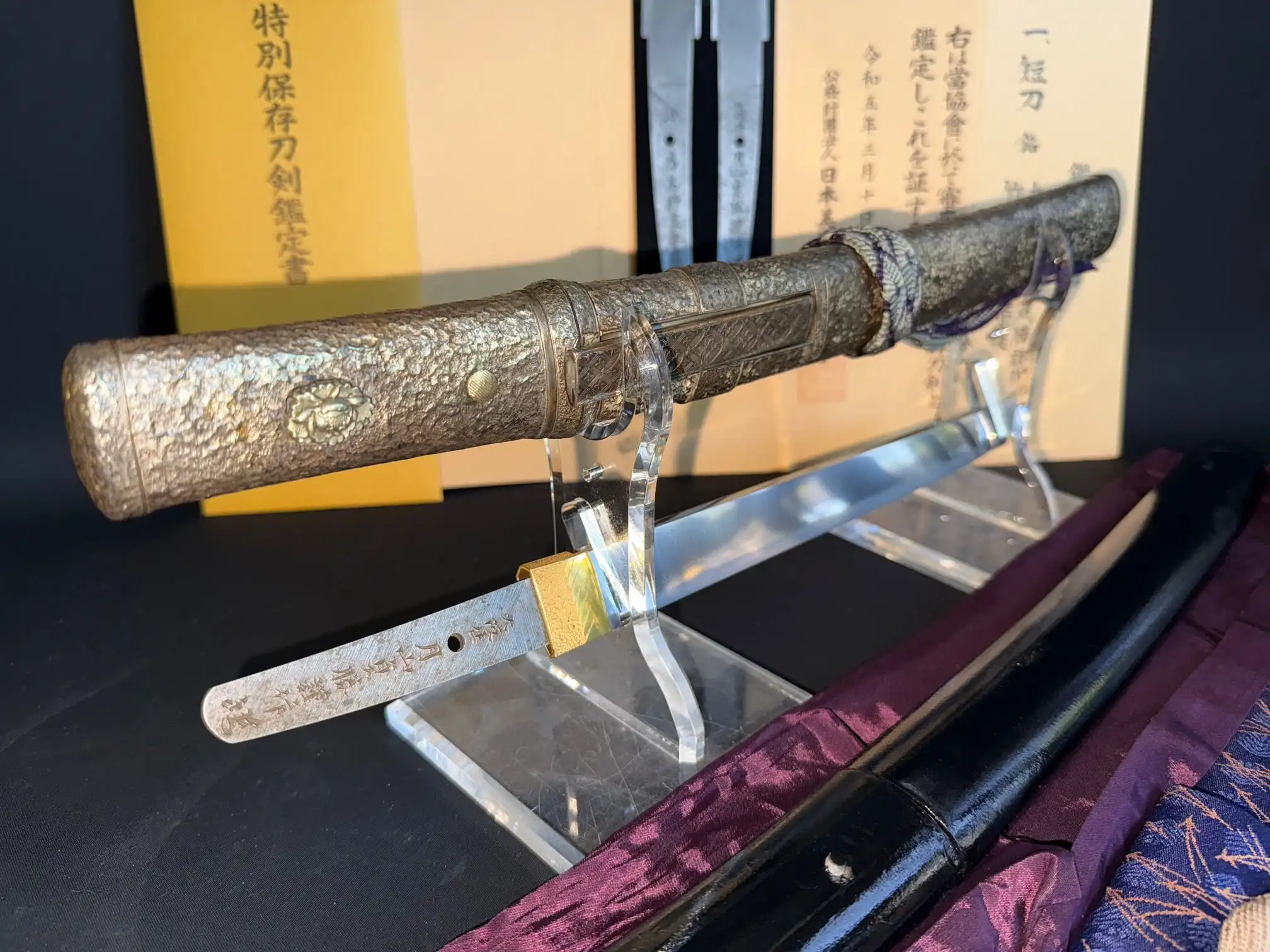 Tanto Gassan Sadakatsu, a Japanese masterpiece Tanto, displayed with its detailed hilt and exposed tang.