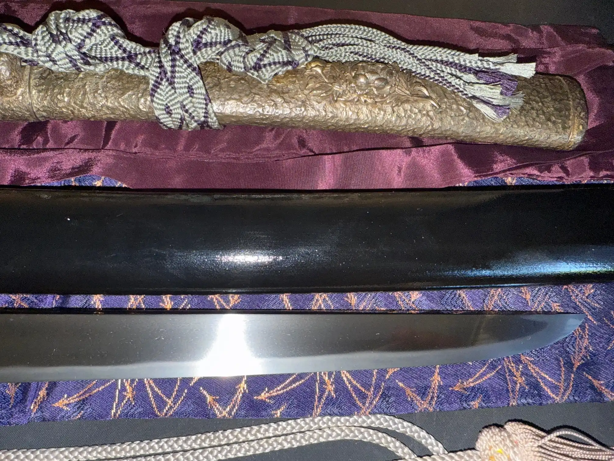 Tanto Gassan Sadakatsu, with its ornate golden scabbard, cord, and polished steel blade partly visible