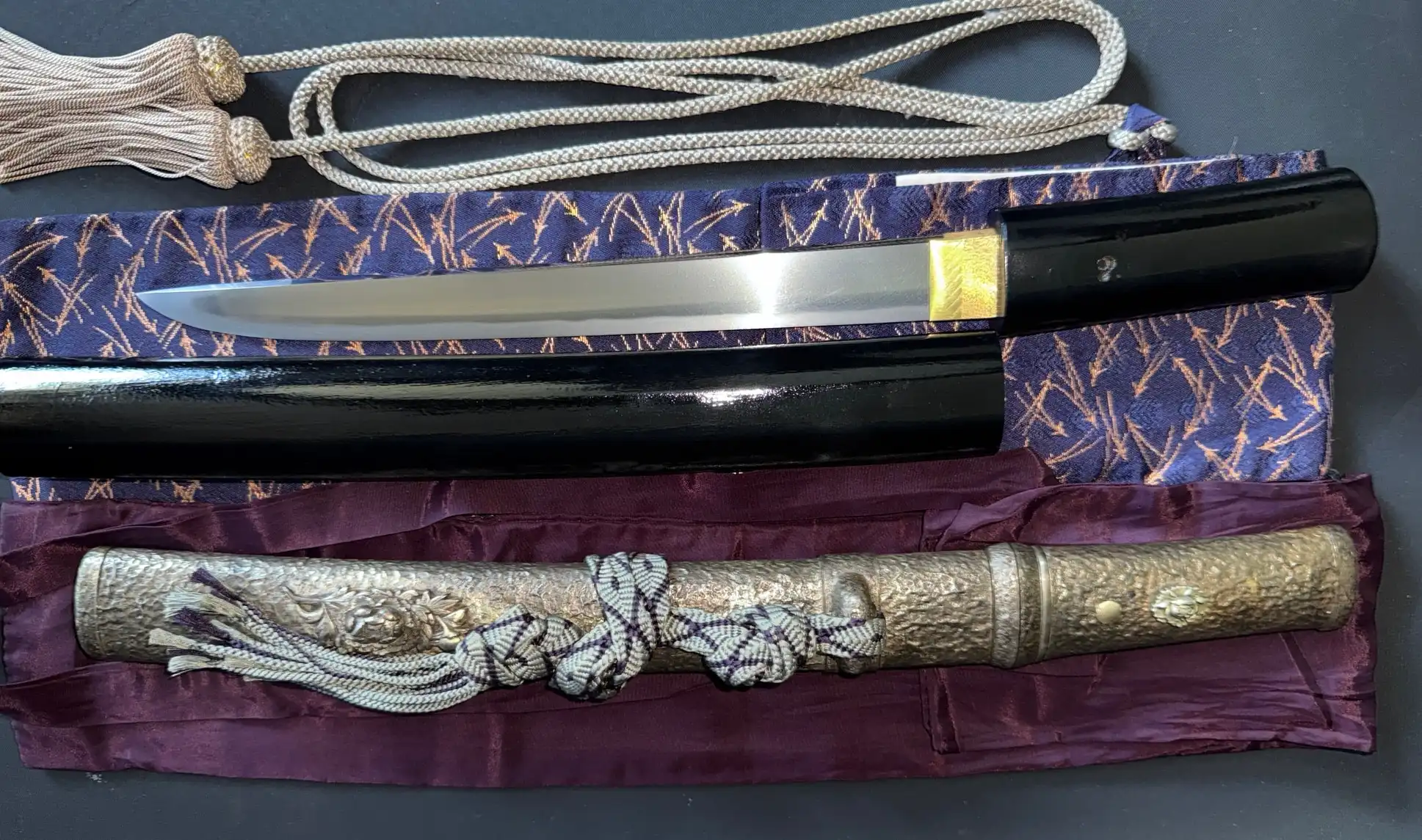 Tanto Gassan Sadakatsu (blade and koshirae) displayed with golden habaki and black saya