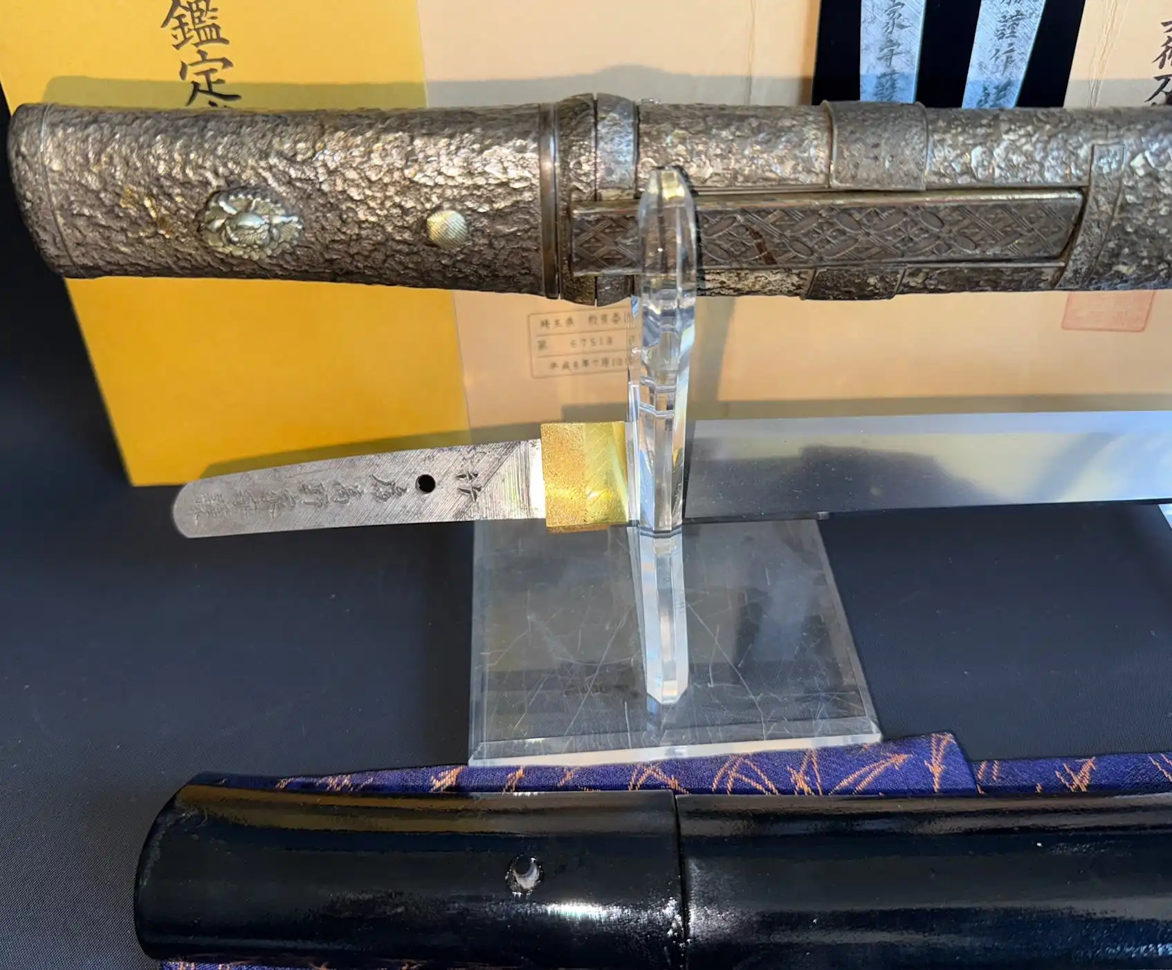 Close-up of a Tanto Gassan Sadakatsu, the handle with hammered metal and a detailed small ornament.
